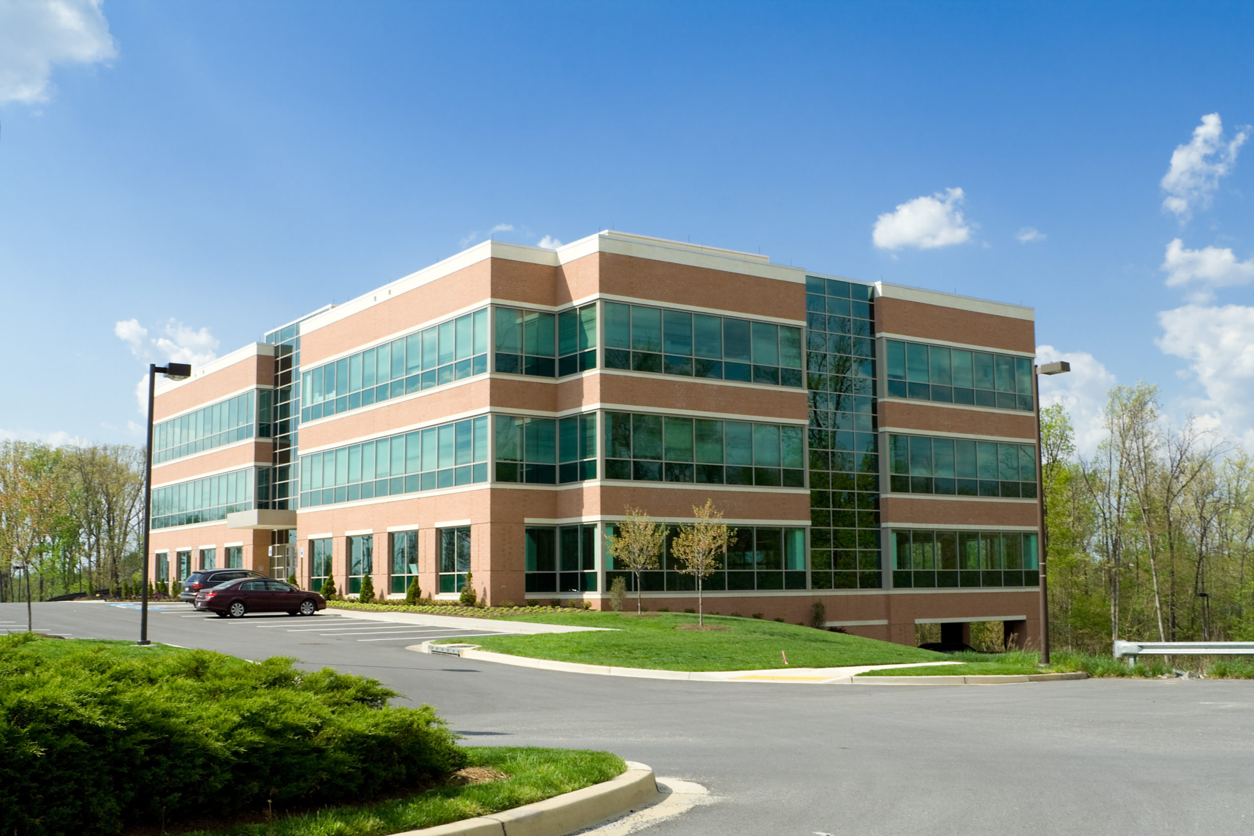 New office building in suburban Maryland, United States.  Parking lot in front of the building with several cars.  - See lightbox for more